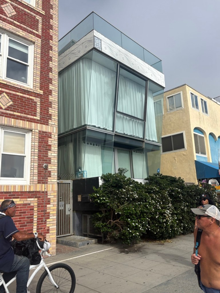 Narrow modern glass home between existing buildings
